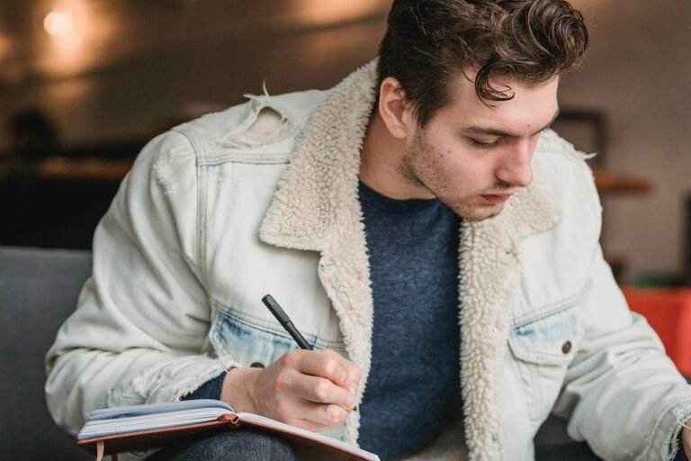 A young man using a productivity journal