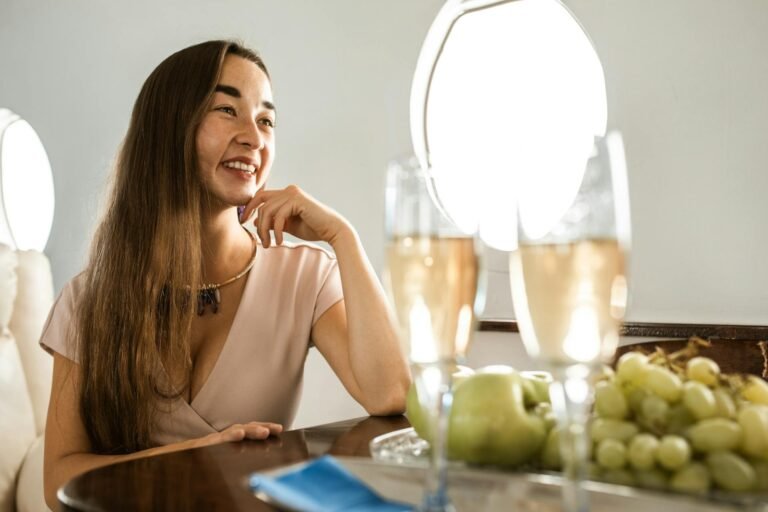 Rich thinking woman in airplane drinking champagne
